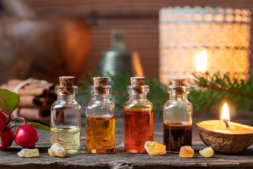 four essential oil bottles with candle, rocks