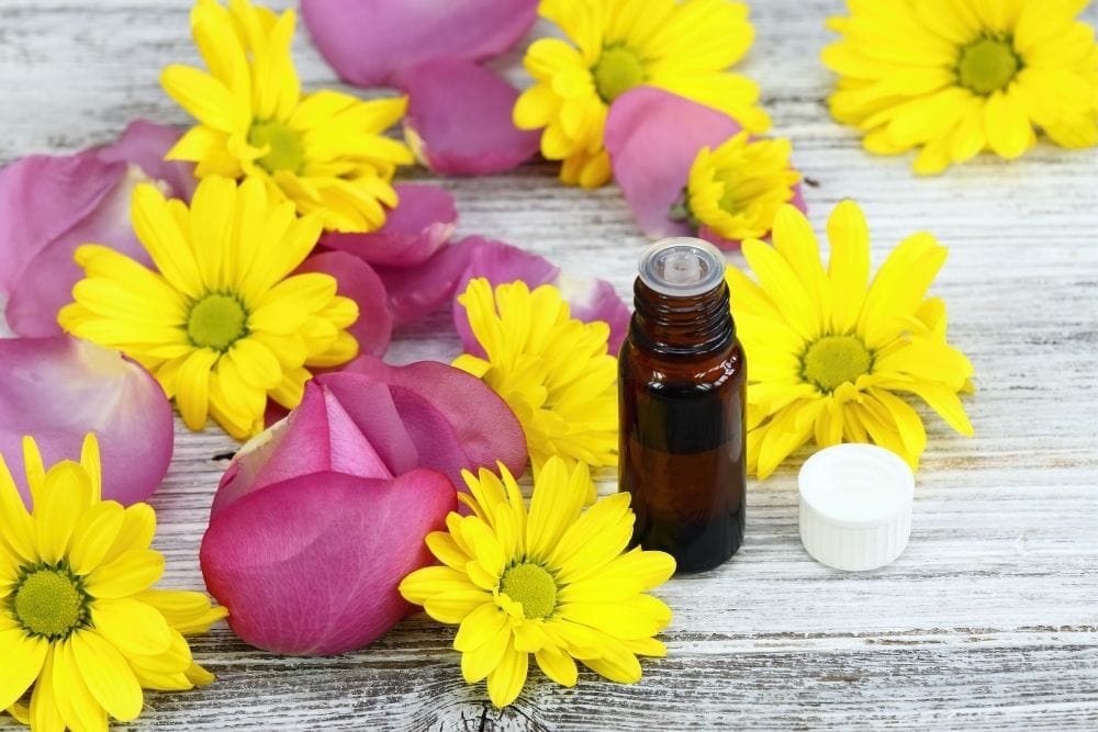 Essential oil bottle and flowers