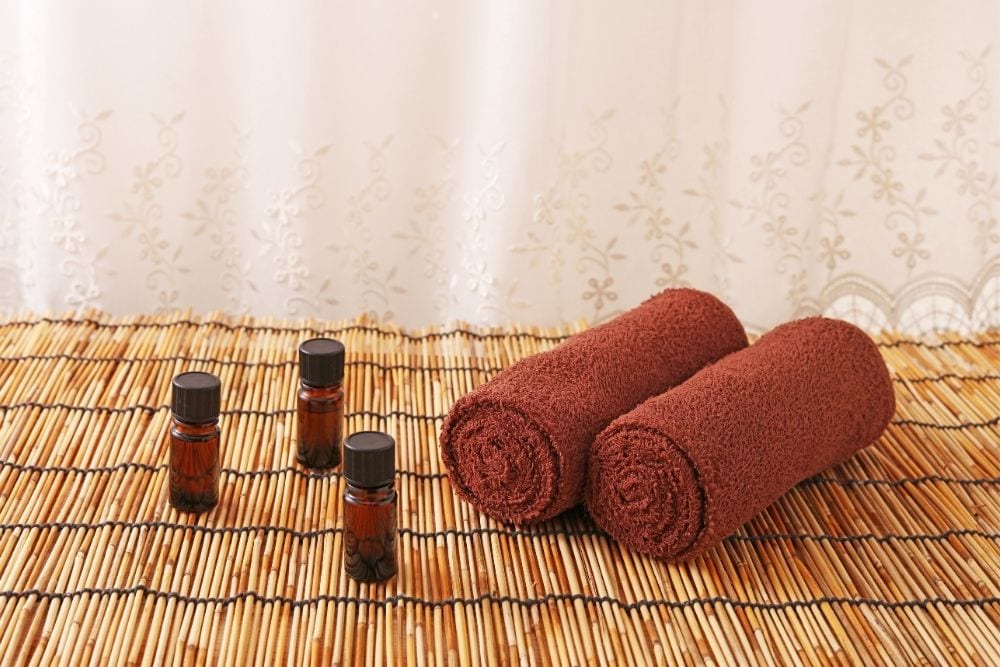 three essential oil bottles with two towels