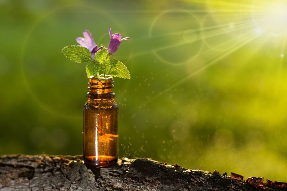 an oil bottle with two flowers on it put on a wood