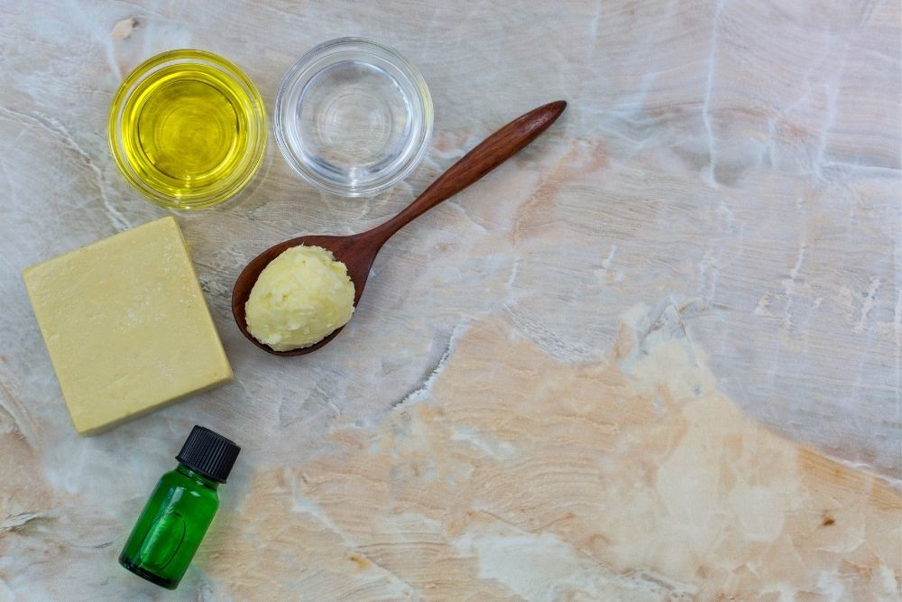 cups, oil bottle, spoon & soap on a rock table